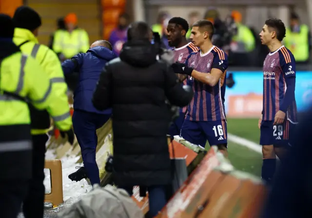 Forest players go over to the fans in the midst of a medical emergency.