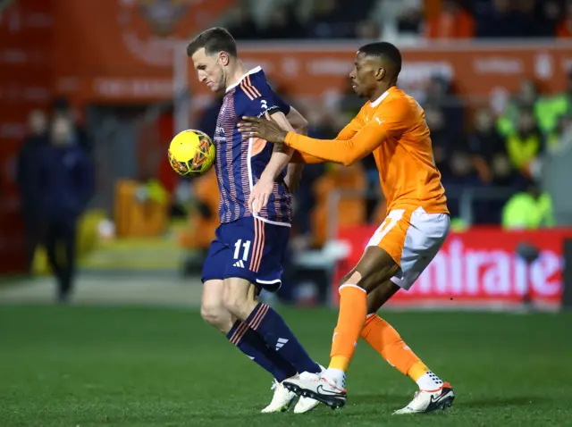 Chris Wood holds off the challenge of a Blackpool defender.