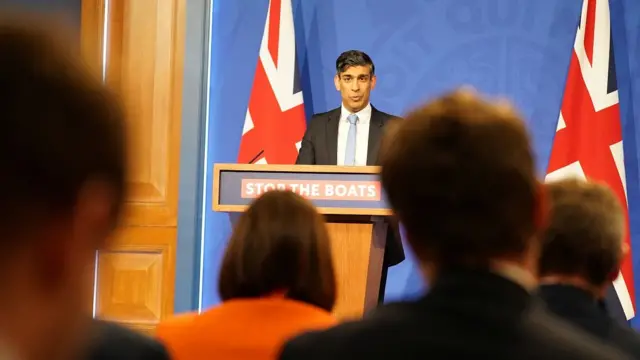 Sunak speaks in front of reporters at the Downing Street briefing room