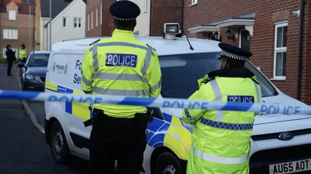 Police officers and a forensic van inside the cordon