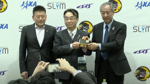 Jaxa exectutives pose with model of Slim spacecraft