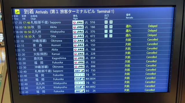 A departure board at Japan's Hanenda Airport shows dozens of cancelled flights.