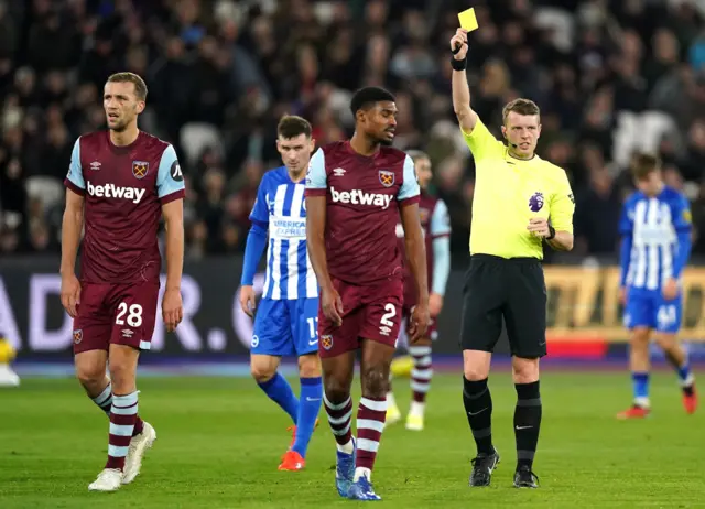 Johnson walks away from the referee as he is shown a yellow card.