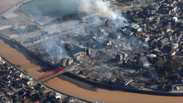 An aerial view shows damaged city of Wajima by strong earthquake, central Japan, the Sea of Japan side, 02 January 2024 while white smokes rise over the city