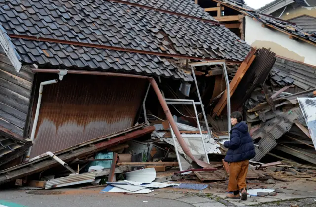 A woman stood outside a collapsed building