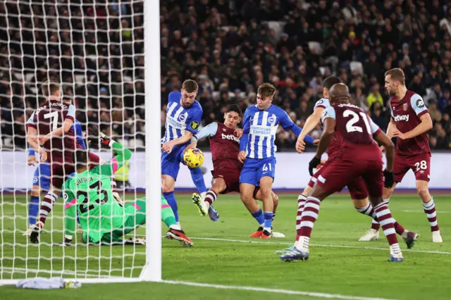 Hinshelwood shoots goalwards among a crowd of bodies.