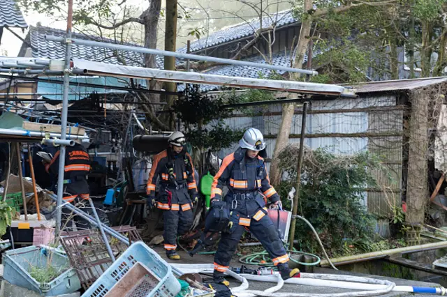 Firefighters investigate a partly burned and collapsed house in Nanao