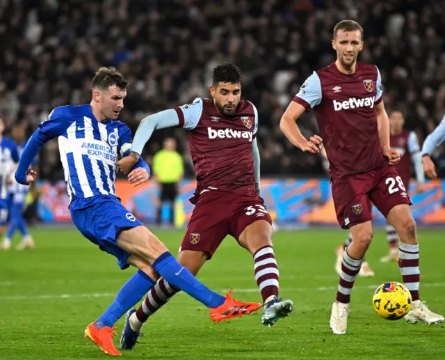 Gross takes aim at goal under pressure from the West Ham defence.