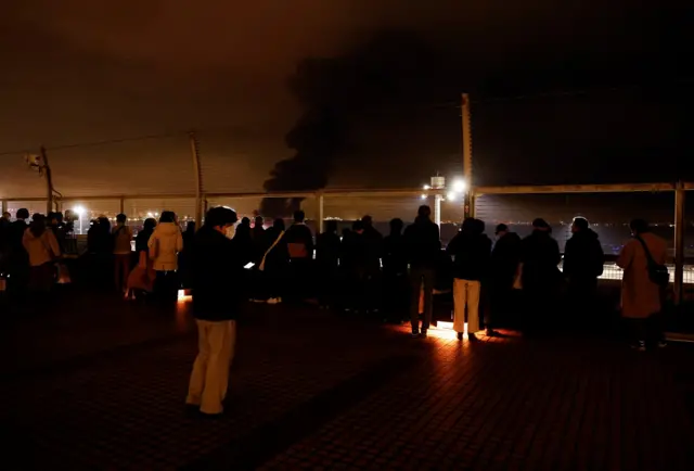 People watch the plane on fire from the observation deck