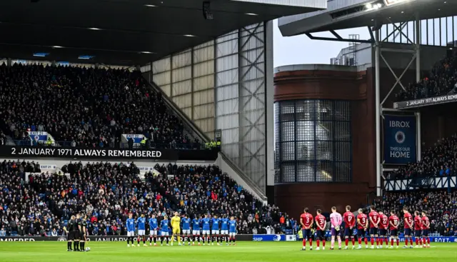 Rangers and Kilmarnock players observing a minute's silence at Ibrox