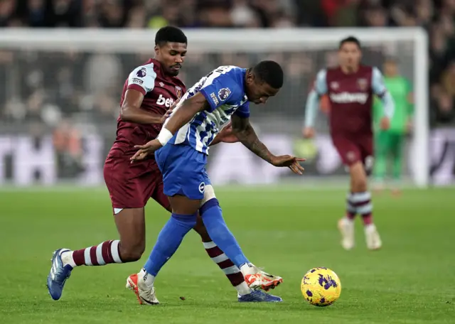 Johnson and Estupinan duel for the ball in midfield.