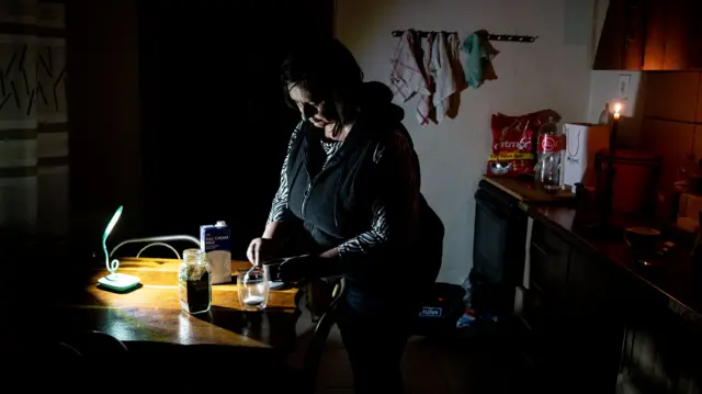 Marina Van Biljon makes a cup of coffee in her home during loadshedding in Frankfort on May 10, 2023.