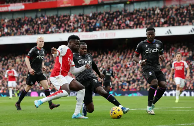 Bukayo Saka runs into the box and attempts to cross the ball.