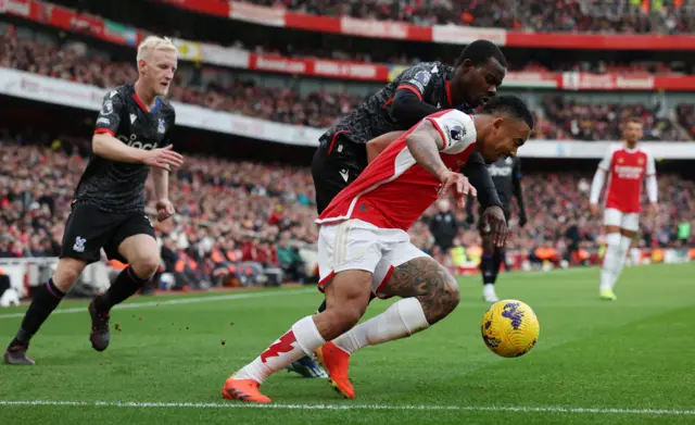 Jesus goes to ground under pressure from two defenders.