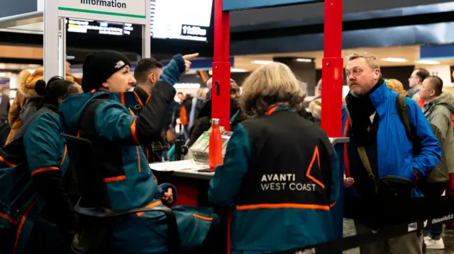 Avanti train staff point passengers in the right direction at London's Euston station