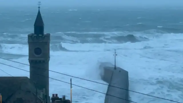 Waves hit Porthleven in Cornwall earlier today