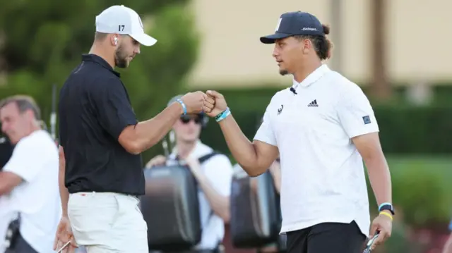 Josh Allen and Patrick Mahomes shake hands while playing golf