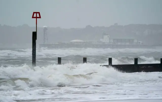 Waves crash against a groyne at Boscombe beach in Dorset