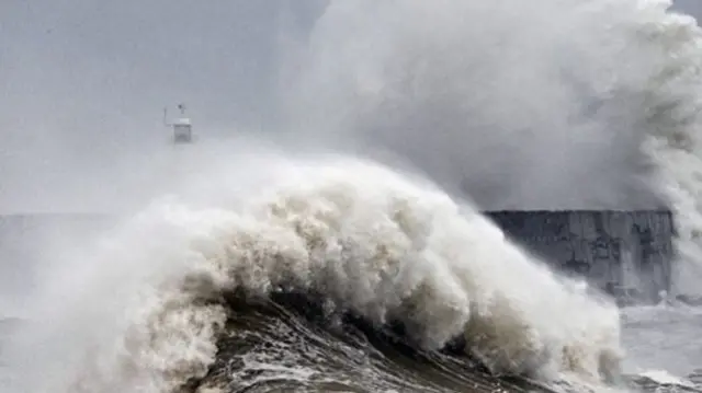 A storm wave hitting a harbour wall