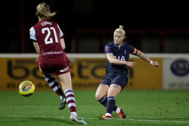 England shoots at goal as a defender looks to get a block in.