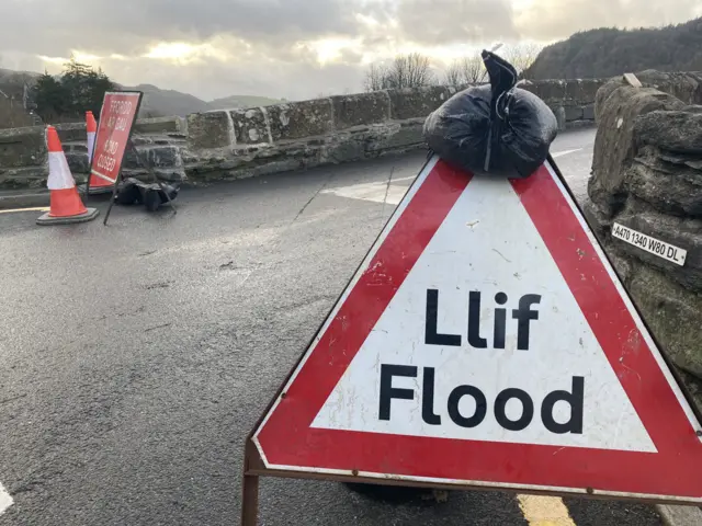 Road signs read "Llif / Flood"