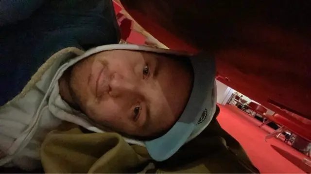 Air traveller, Luke Bromage-Henry, lying underneath chairs at Paris Charles de Gaulle airport