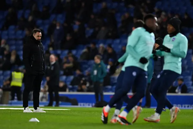 Roberto De Zerbi (L) watches his players warm up
