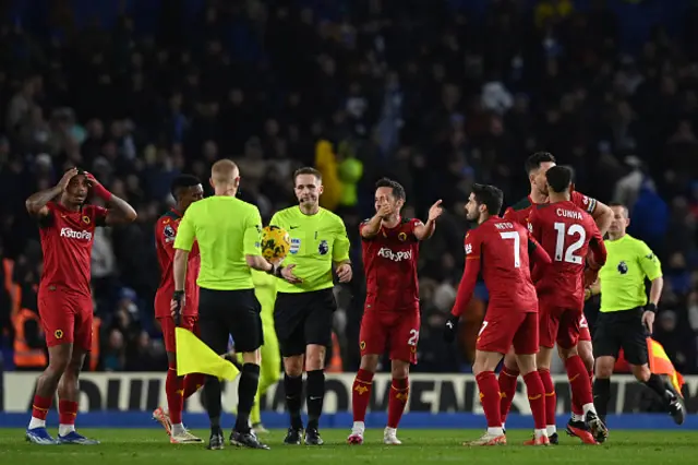 Wolves' players surround English referee Craig Pawson