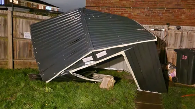 A broken metal shed in a garden