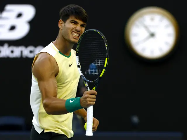 Carlos Alcaraz shakes his racquet in celebration