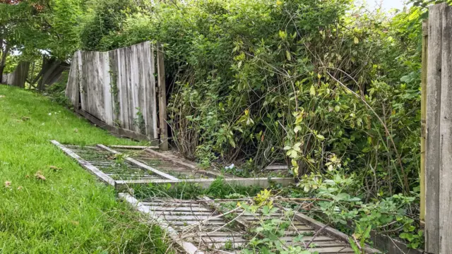 Wooden garden fence panel on the ground in a residential area near Pontypridd after being blown over by the strong winds of a storm