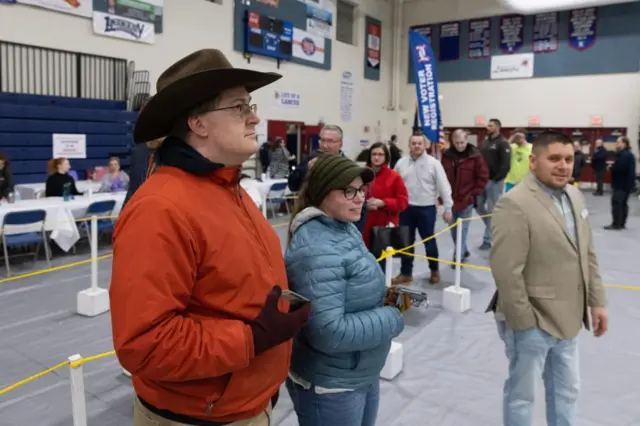 Voters wait in line to get a ballot and vote in the New Hampshire primary, at a voting site at Londonderry High School in Londonderry, New Hampshire