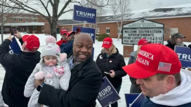 Tim Scott holds a baby