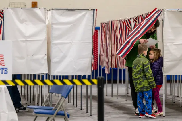 A person casts their ballot in the New Hampshire Primary at Londonderry High School