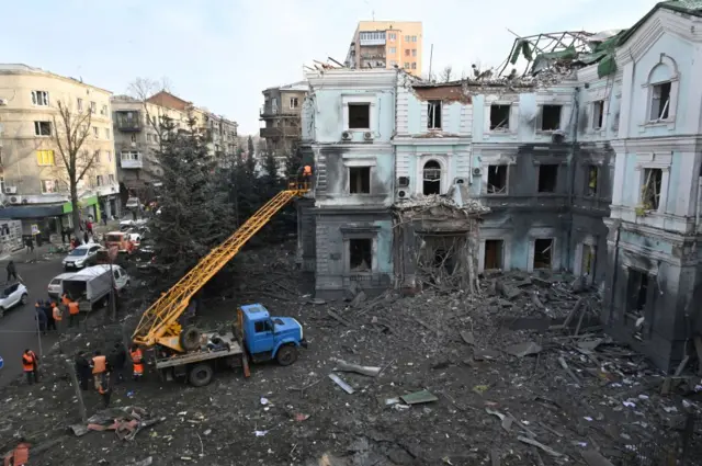 A damaged building in Kharkiv is inspected