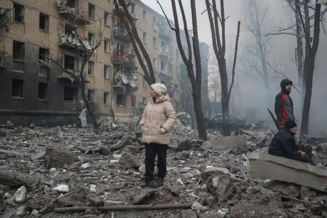 A woman standing on a pile of rubble