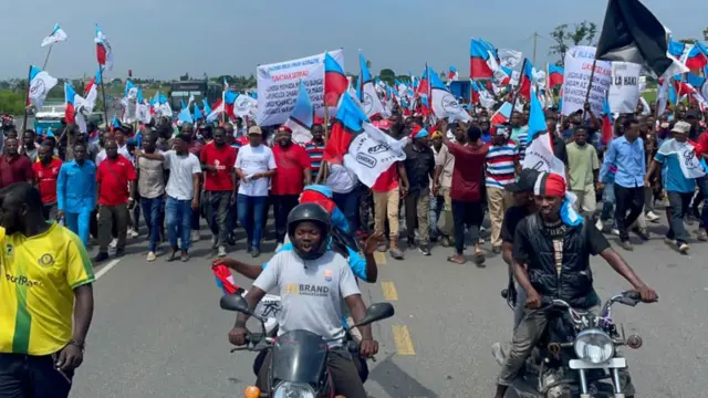 Demonstrators waving flags and riding motorbikes at a protest in Dar es Salaam, Tanzania