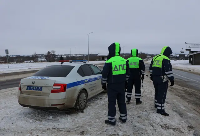 Police standing beside a car at a roadblock in Yablonovo