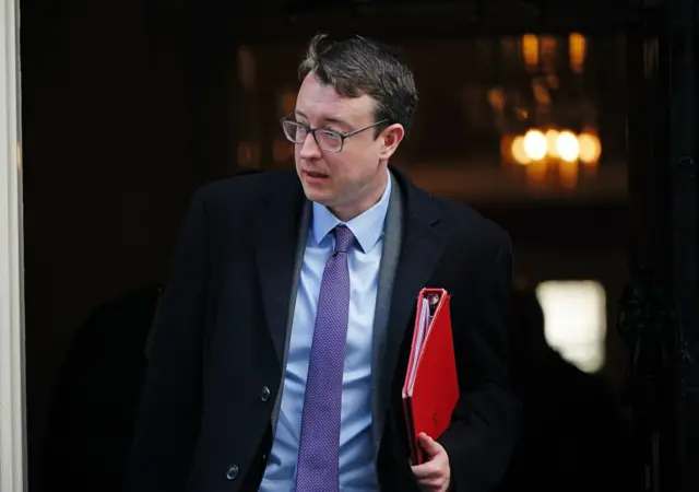 Former cabinet minister Sir Simon Clarke walking with a red binder in his hand