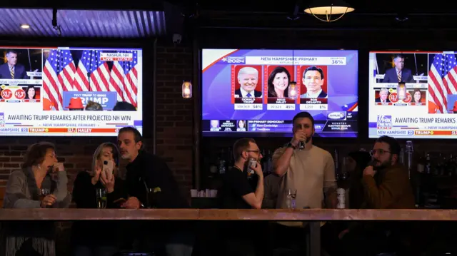 People drinking in a bar watching the New Hampshire primary