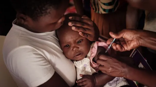 A child receives a shot during the launch of the extension of the worlds first malaria vaccine (RTS, S)