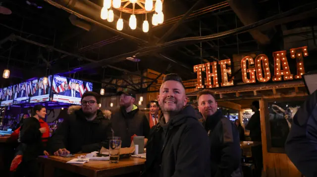 People in a bar watching the New Hampshire primary