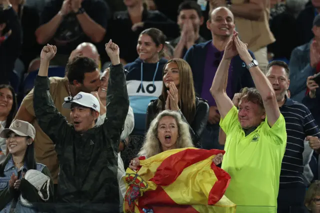 Fans of Carlos Alcaraz celebrate in the crowd