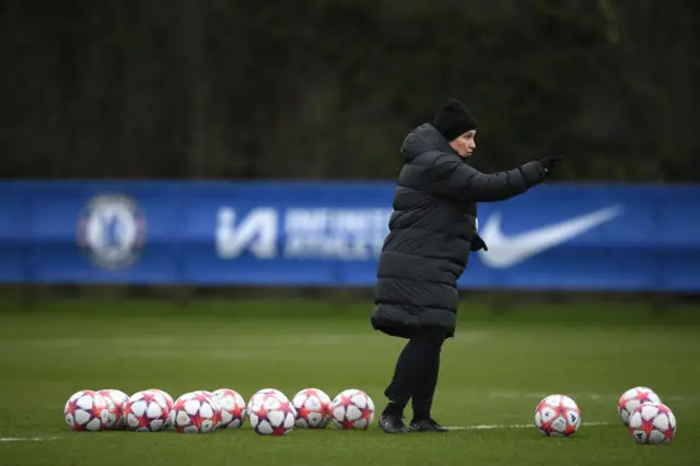 Emma Hayes shouts instructions in training while surrounded by matchballs.