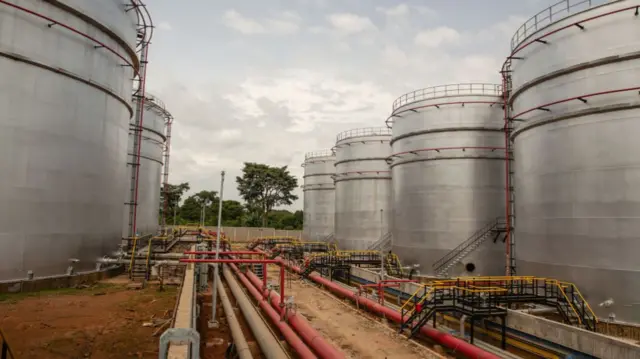 Pipework runs alongside fuel storage tanks at the Mahathi Infra Uganda Ltd. oil logistics complex on the shore of Lake Victoria in Entebbe, outside Kampala, Uganda, on Wednesday, Dec. 15, 2021.