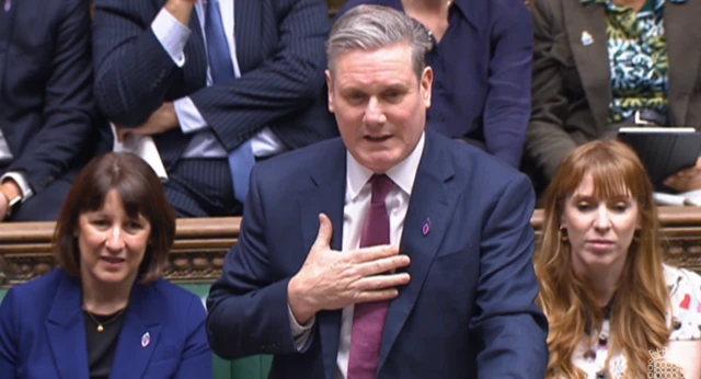 Starmer speaking in the House of Commons, gesturing with his right hand on his chest