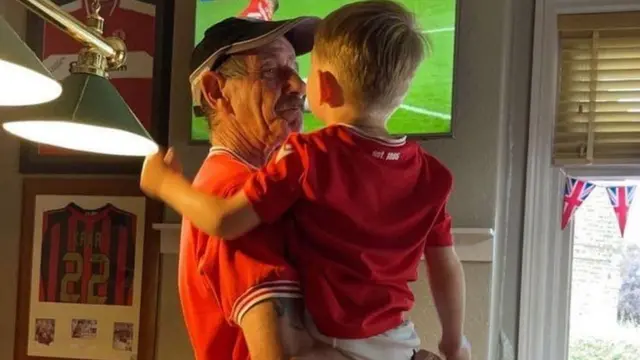 Ian Coates holding up his grandson