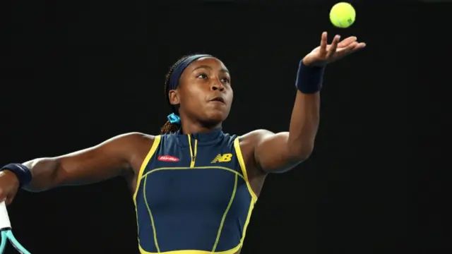 Coco Gauff throws the ball to serve