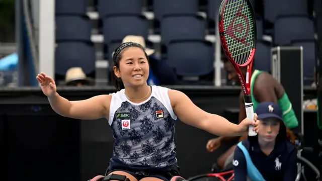 Yui Kamiji celebrates by waving to the crowd after her match win