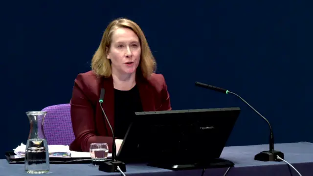 Liz Lloyd sitting in room in front of laptop